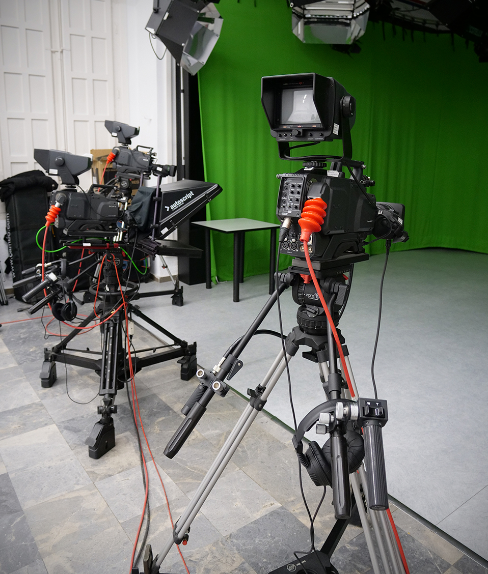 Imagen que muestra diverso equipamiento audiovisual para la grabación sobre un croma de color verde situado en la Facultad de Comunicación y Documentación
