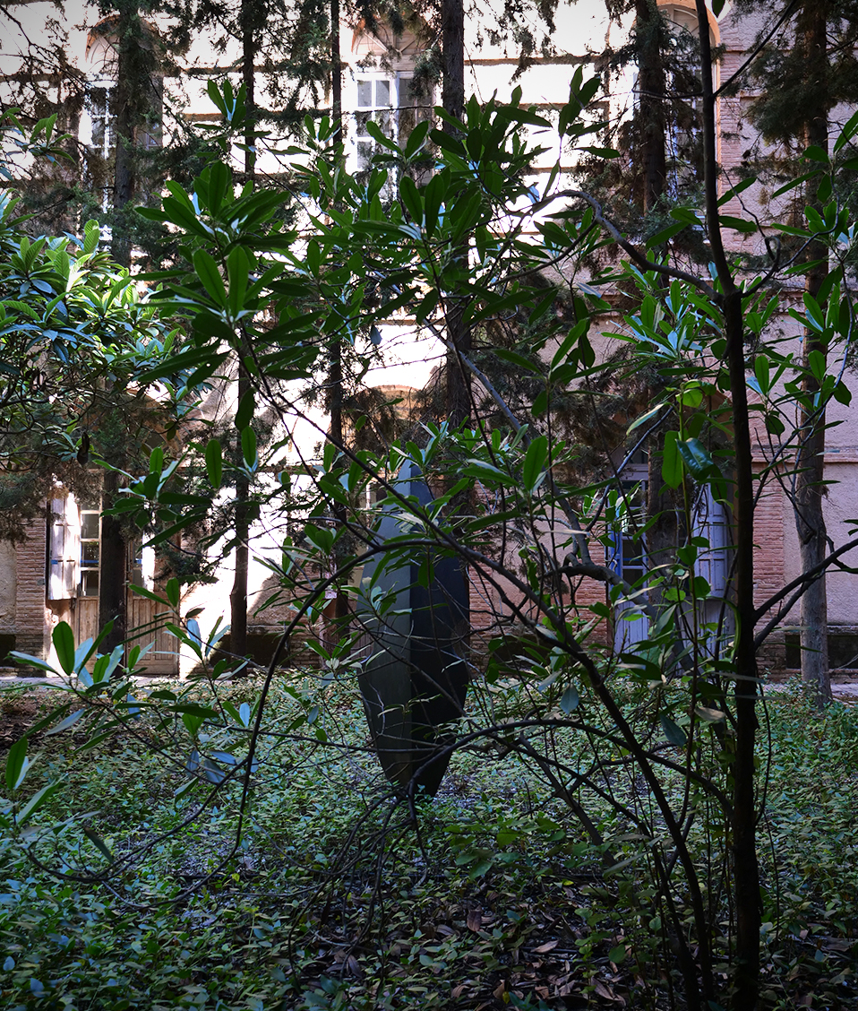Jardín exterior de la Facultad de Comunicación y Documentación donde se puede ver una escultura abstracta